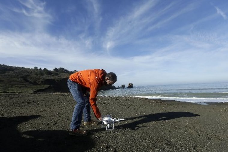 Image: Trent Lukaczyk sets up drone to take photos and videos over coastline in Pacifica, Calif.
