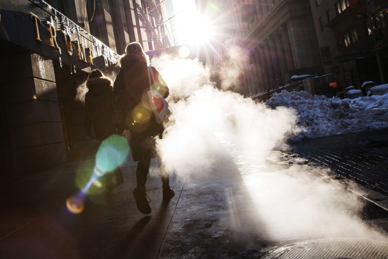 Image: A woman walks through a cloud of steam two days after a massive snow storm covered the East Coast