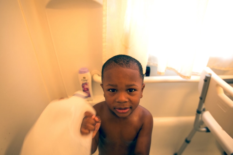 Dana Brock, 3, gets bathed in water from a jug. His family thinks lead is at the root of his health problems.