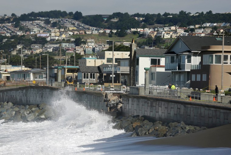 Image: Waves crash near a damaged section of the seawall