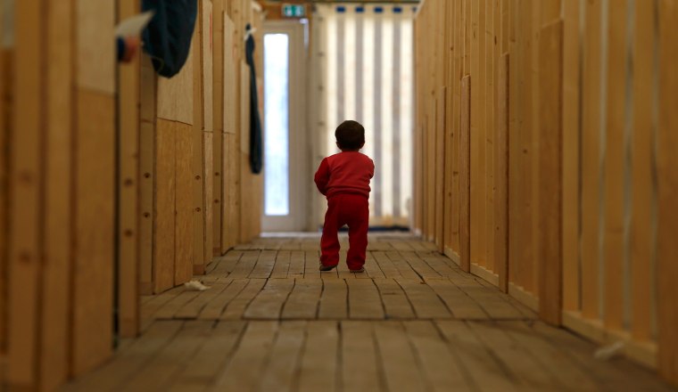 Image: A migrant child walks through the first registration camp of Erding near Munich