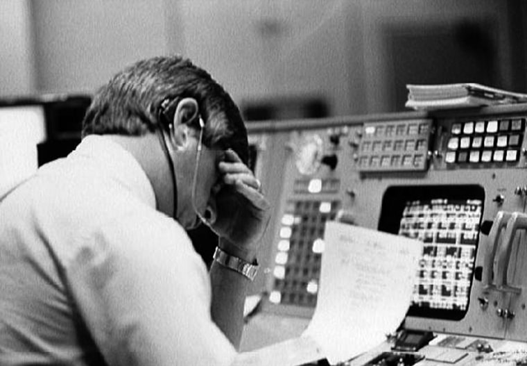 Image: Flight director Jay Greene studies data at his console inside Johnson Space Center's Mission Control Center