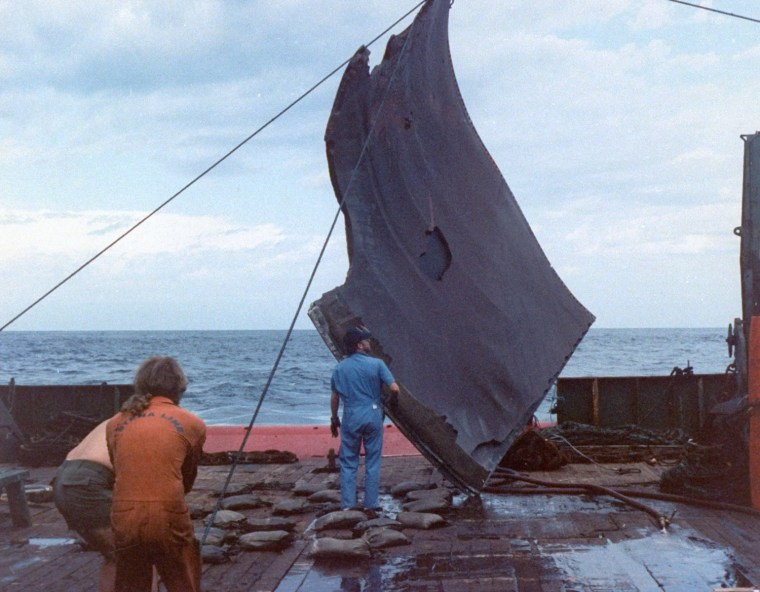 Image: A piece of debris from the space shuttle Challenger is hoisted onto the deck of the Stena Workhorse