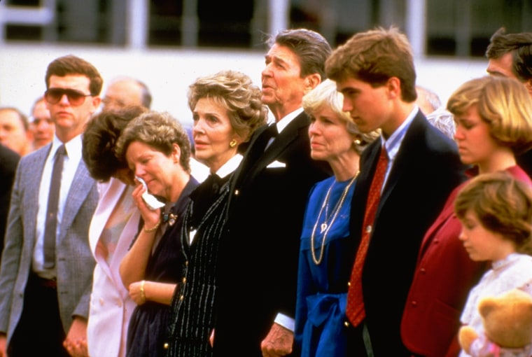 Image: President Ronald Reagan and his wife stand with the wife of astronaut Michael Smith and other family members at a memorial service