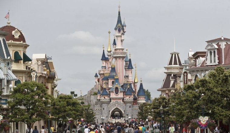 Visitors walk toward Sleeping Beauty's Castle at Disneyland Paris in Chessy, France, on May 12, 2015.