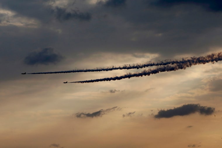 Image: Super Etendard fighter jets dump fuel after a mission, before landing on France's flagship Charles de Gaulle aircraft carrier in the Gulf
