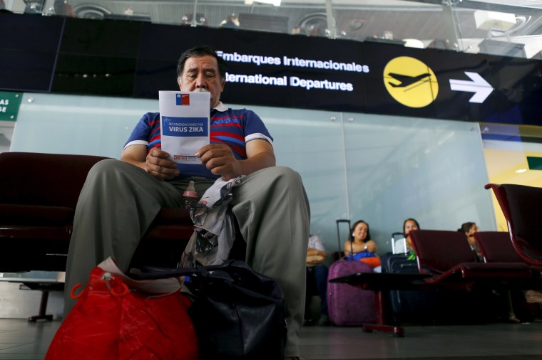 Image: A man reads a zika virus flyer from an information campaign by the Chilean Health Ministry at the departures area of Santiago's international airport