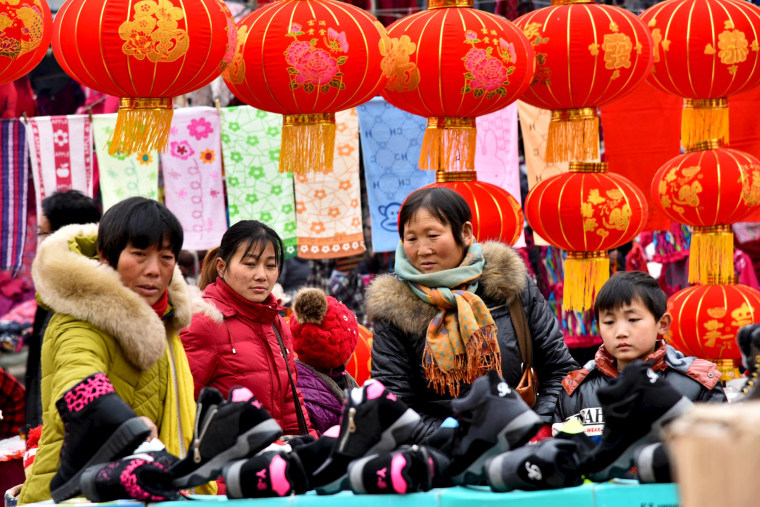 Image: People shop at a new year market ahead of the upcoming Spring Festival in Zaozhuang
