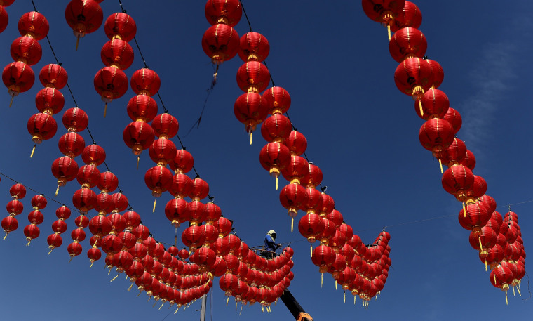 Image: A Malaysian worker puts up traditional Chinese lanterns
