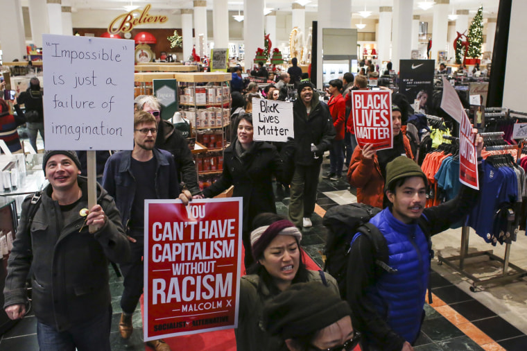 Image: Black Lives Matter protesters walk through a Macy's store on Black Friday in Seattle, Washington