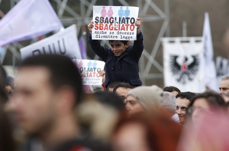 Image: A child holds a sign reading "It is wrong even if it becomes law" during a rally against same-sex unions and gay adoption in Rome