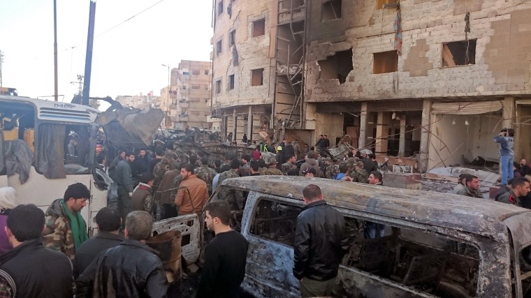 Image: Residents and soldiers loyal to Syria's President Bashar al-Assad inspect damage after a suicide attack in Sayeda Zeinab