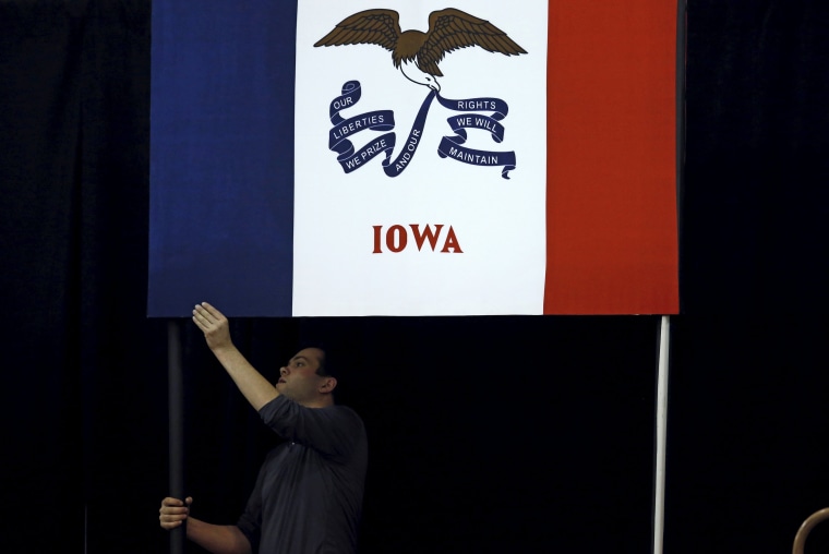 Image: A campaign worker hangs a flag for a U.S. Republican presidential candidate Ted Cruz campaign event in Des Moines