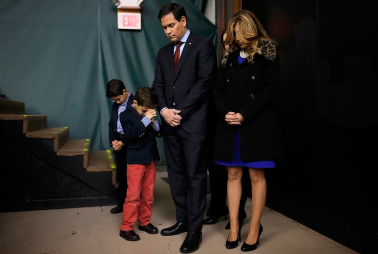Image: Republican U.S. presidential candidate Marco Rubio prays with his family as they attend the Republican caucus at the 7 Flags Event Center in Clive
