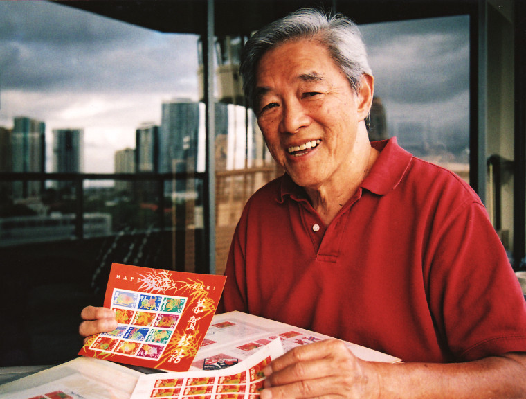 This 2008 photo, taken in Honolulu, shows artist Clarence Lee holding a sheet of the first Lunar New Year stamp series he designed. Lee died in January 2015 at the age of 79.