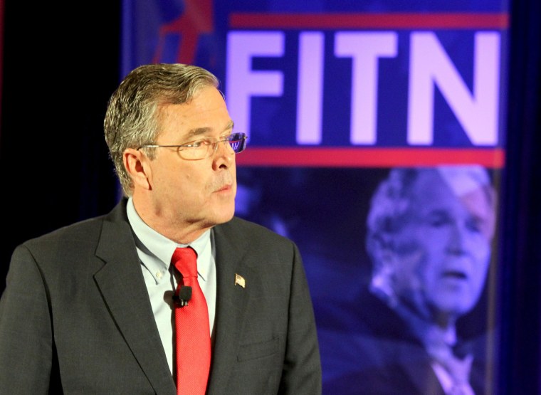Image: U.S. Republican presidential candidate Jeb Bush stands in front of a photo of former president and brother George W. Bush as he speaks at the New Hampshire GOP's FITN Presidential town hall in Nashua