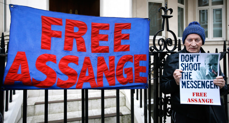 Image: A demonstrator holds a banner outside the Ecuadorean Embassy  in London