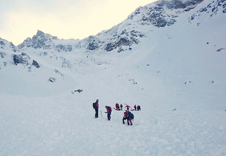 Image: Rescue teams arrive to search for a group of people buried by an avalanche