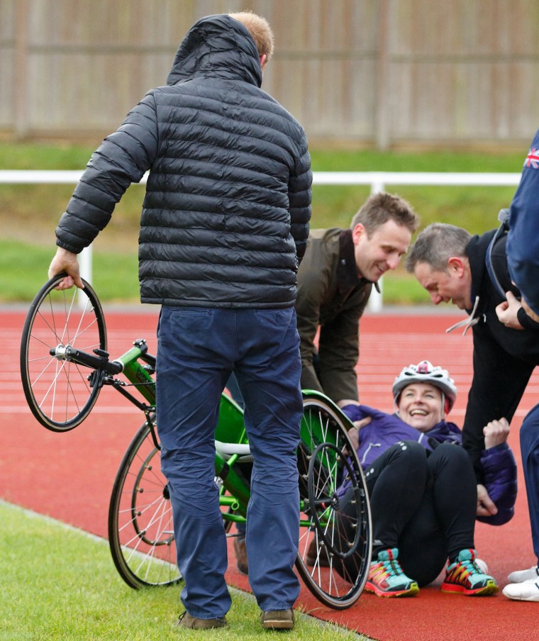 Image: Prince Harry helps a woman back into her wheelchair at the UK Team Trials for the Invictus Games