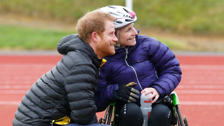 Image: Prince Harry poses for a picture with an athlete he helped after she fell out of her wheelchair