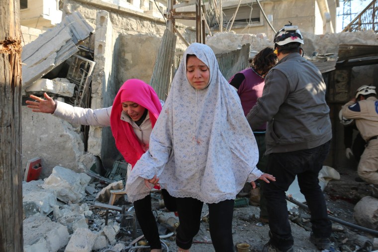 Image: Girls react following a reported Syrian regime air strike in Aleppo on Monday.