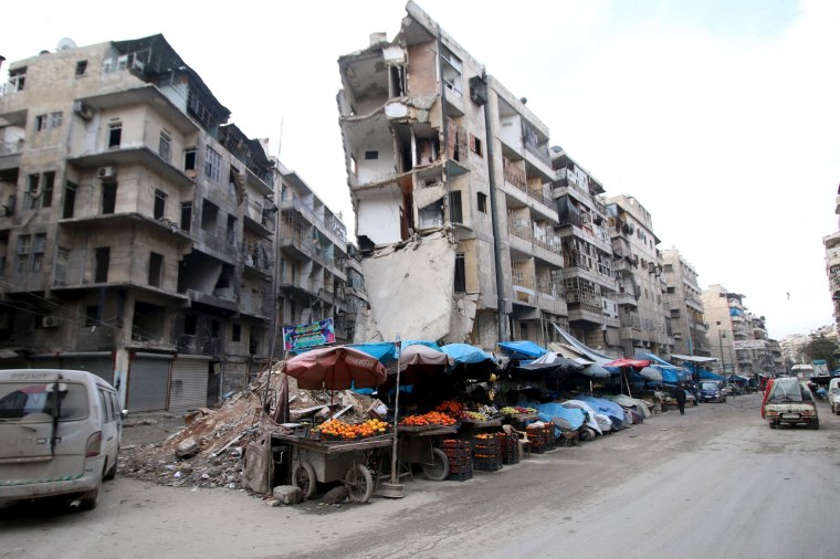 Image: Stalls are seen on a street beside damaged buildings in the rebel held al-Shaar neighborhood of Aleppo