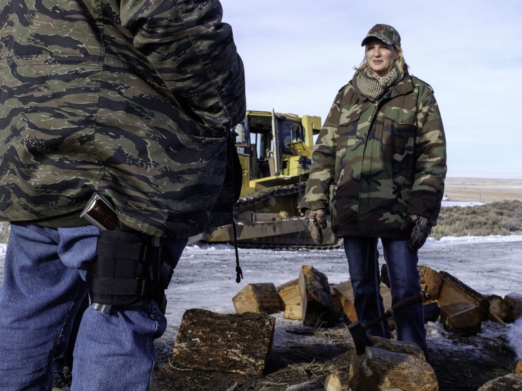 Image: Sean Anderson, left, with a handgun strapped to his leg, his wife Sandy Anderson