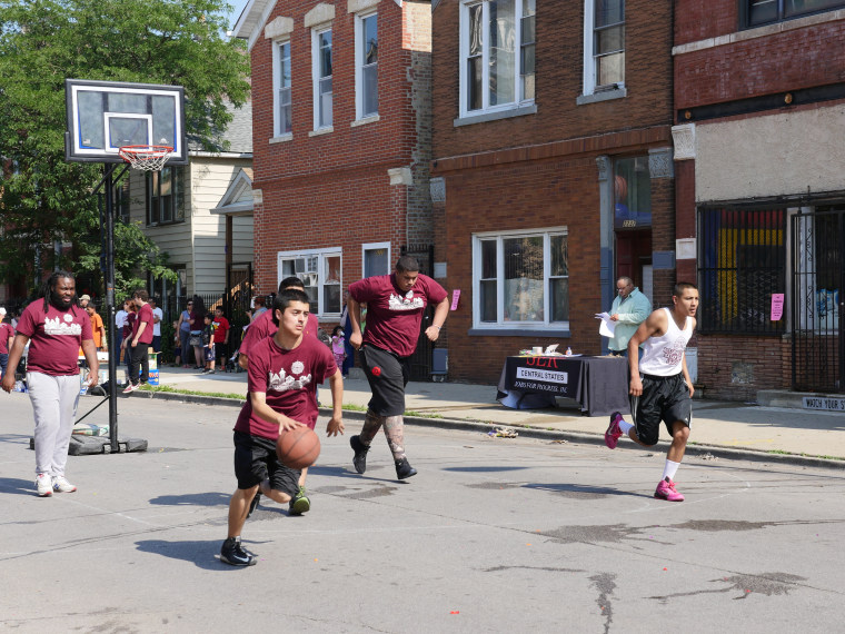 Children and adults playing basketball in the street in Pilsen