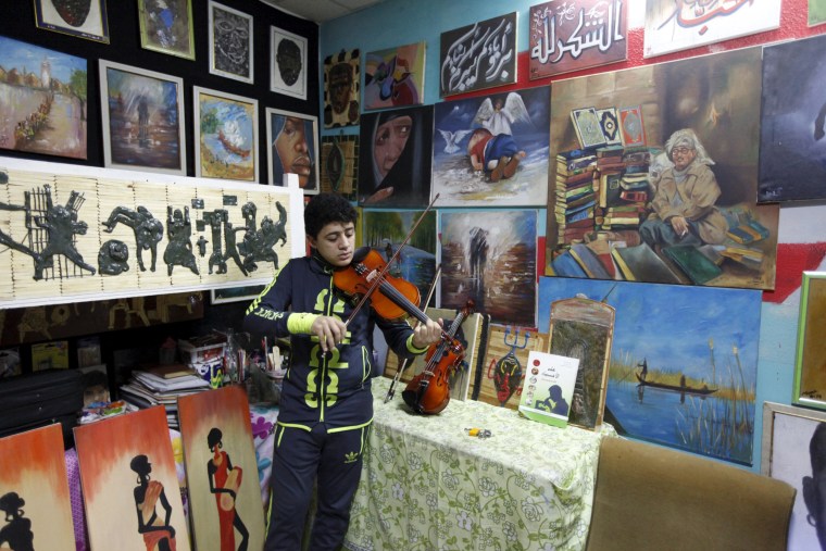 Image: An orphan boy plays music at the Iraqi Safe House for Creativity in Baghdad