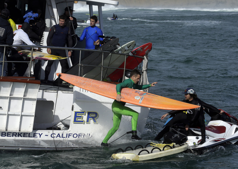 Image: Nic Lamb jumps to a jet ski with his board during the finals