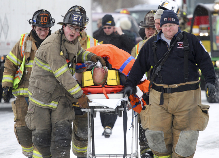 Image: Emergency personnel carry someone away from a crash scene near Fredericksburg, Pa.