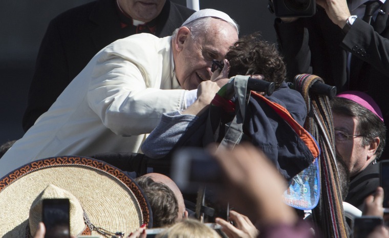 Image: Pope Francis kisses a child in a wheelchair at Mexico City's main sqaure