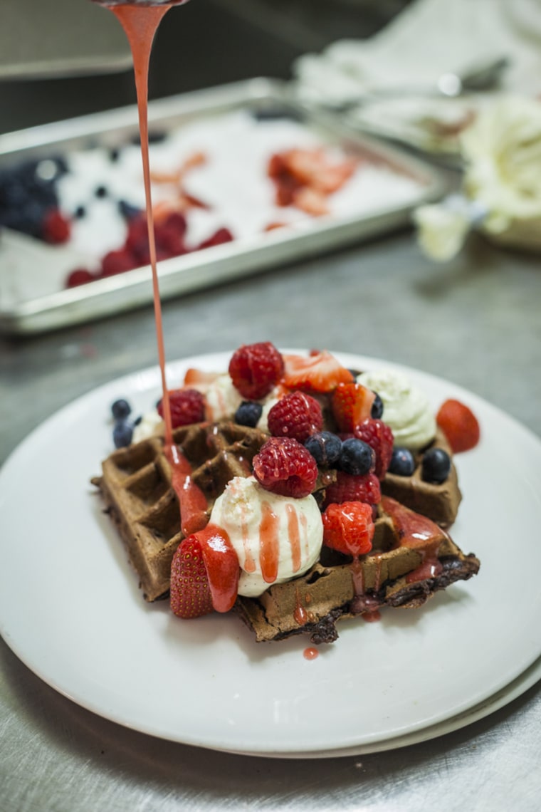 Top the chocolate waffle with the cheesecake mousse, a sprinkle of mixed berries and a drizzle of strawberry sauce