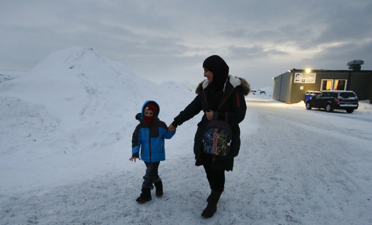 Image: Refugee Huda al-Haggar and her son Omar walk outside the refugee camp in Hammerfest