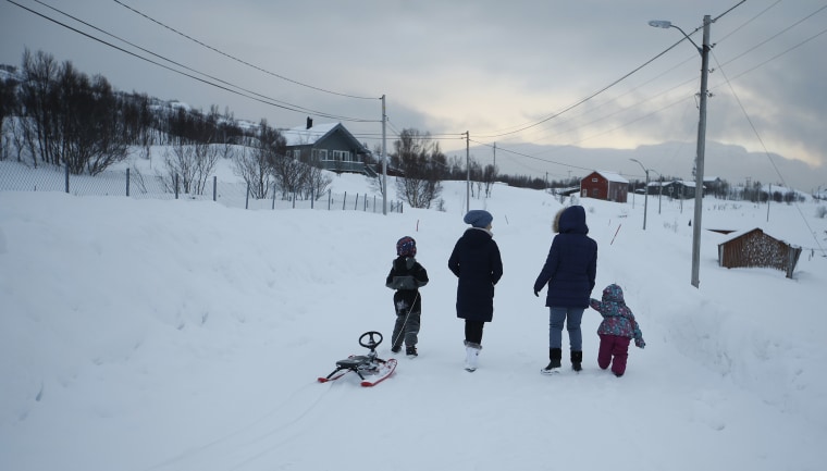 Image: Asylum seekers take their children fro a walk near the temporary accommodation at the Altnes camp