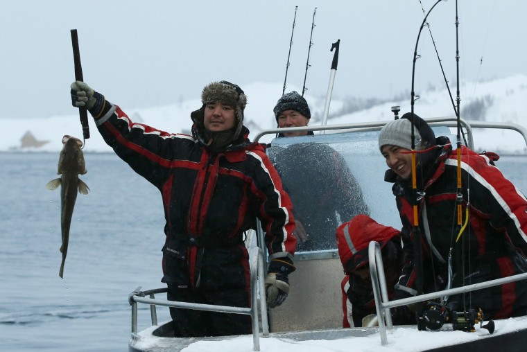 Image: Stig Erland Hansen, center, owner of the Altnes camp, returns from a fishing trip with asylum seekers