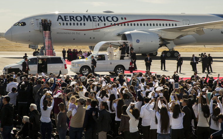 Image: People wave and take pictures of Pope Francis in his popemobile as he arrives to Benito Juarez International Airport
