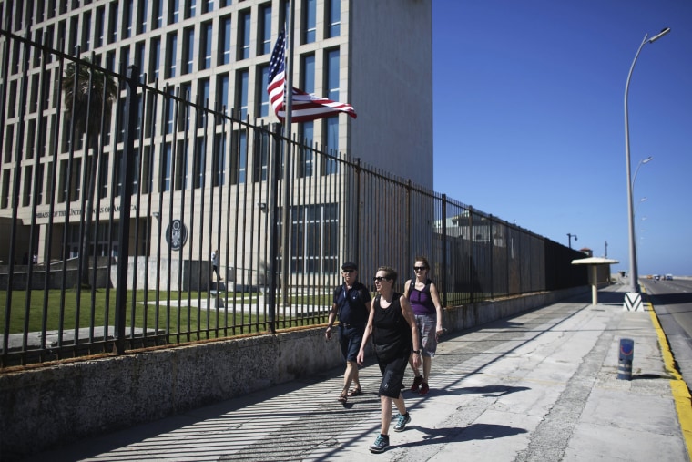 Image: Tourists pass by the U.S. Embassy in Havana