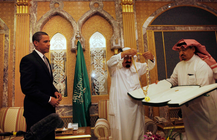 Image: President Barack Obama receives a gift from Saudi King Abdullah at the start of their bilateral meeting