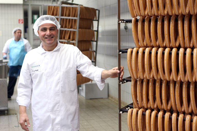Image: An employee stands alongside sausages at the Volkswagen-owned butchery in Wolfsburg