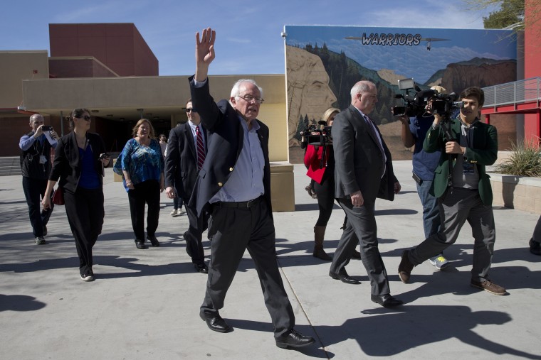 Image: Sanders waves to voters as he leaves a caucus site