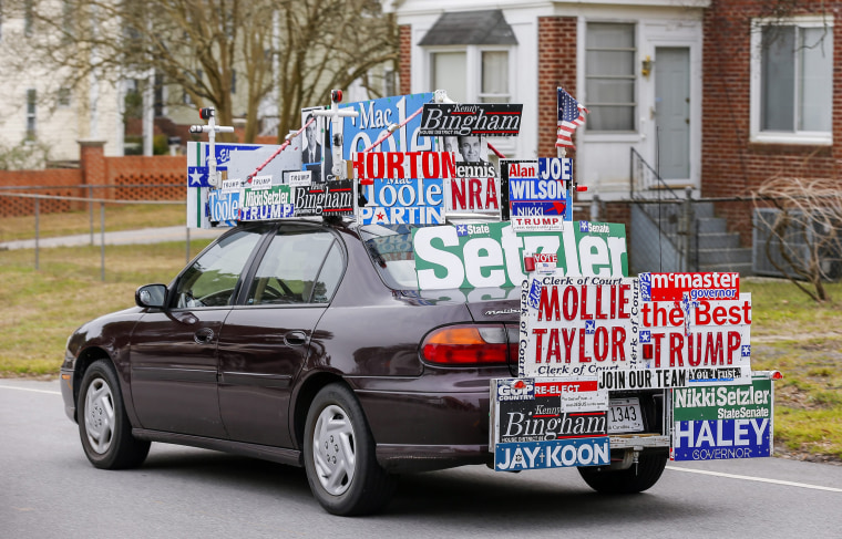 Image: A supporter of businessman Donald Trump and other local candidates drives past a voting precinct