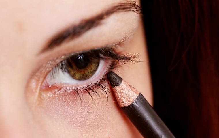 woman applying eyeliner