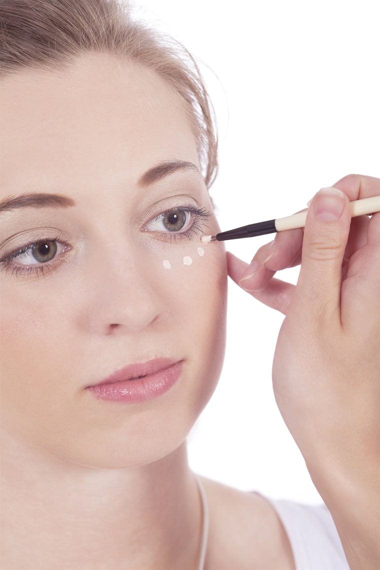 woman applying concealer