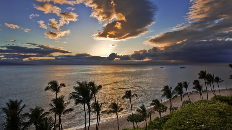 Sunset casts a golden glow over the ocean at Kaanapali Beach on Maui.