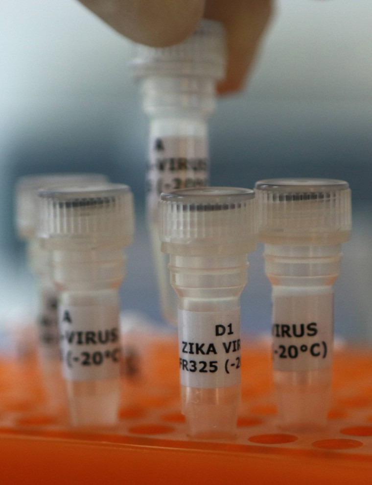 Image: An employee examines tubes with the label 'Zika virus