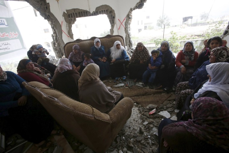 Image: Palestinians gather in the home of Mohammed al-Haroub after it was partially demolished by Israeli army in the West Bank village of Dir Samt
