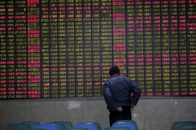 An investor watches an electronic board showing stock information on the first trading day after the week-long Lunar New Year holiday at a brokerage house in Shanghai,