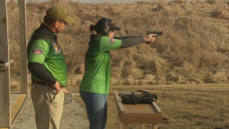 Grace Hood, age 16, conducts a rapid fire practice with a semi-automatic handgun, while her father observes at a gun range near Elkhart, Iowa on Thursday, Feb. 25th.