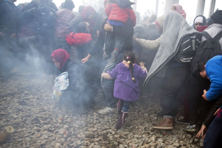 Image: Migrants run after Macedonian police fired tear gas near the northern Greek village of Idomeni Monday.